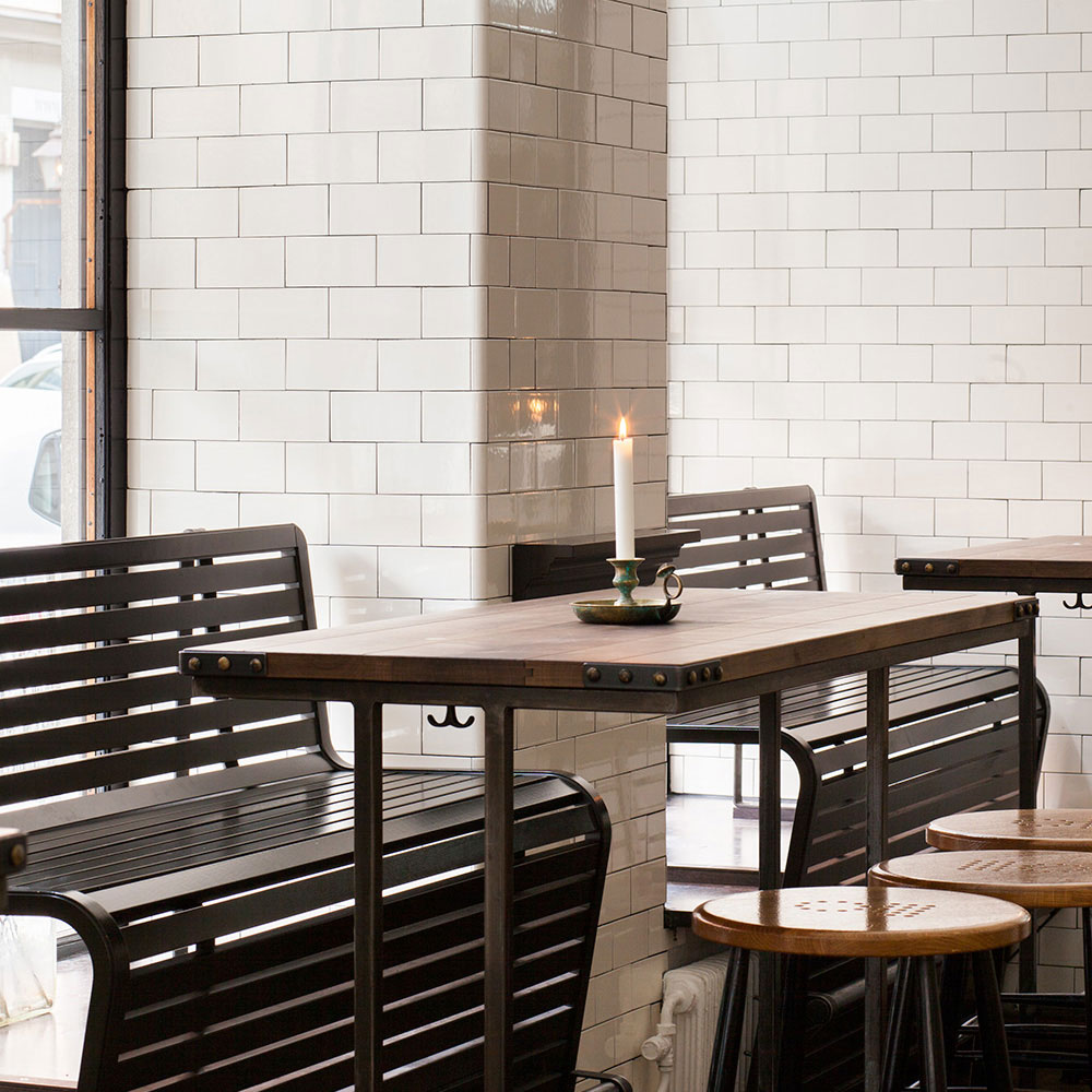 Restaurant med flisebeklædte, cremefarvede vægge.