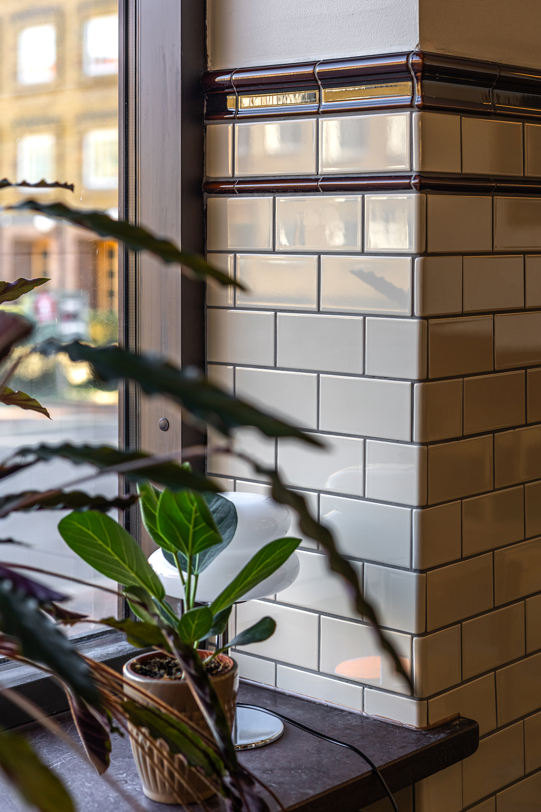 Et flisebelagt hj&oslash;rne med blandt andet fliseliste Victoria i malingen Teapot Brown p&aring; restaurant Freden i Malm&ouml;