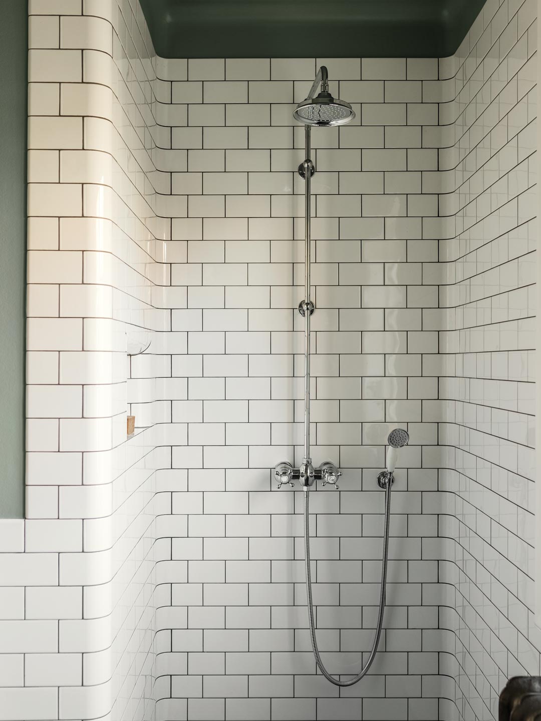 Bruseplads med hvide fliser, grønmalet loft og klassisk krombruser Bruseplads med hvide fliser, grønmalet loft og klassisk krombruser
