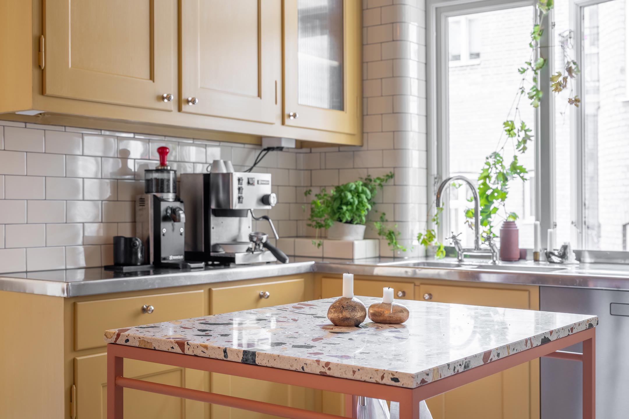 Køkken fra Byggfabriken i sandgul linoliemaling med Magnolia fliser og terrazzo bordplade Sandgult Byggfabriken køkken med Magnolia fliser og terrazzo bordplade