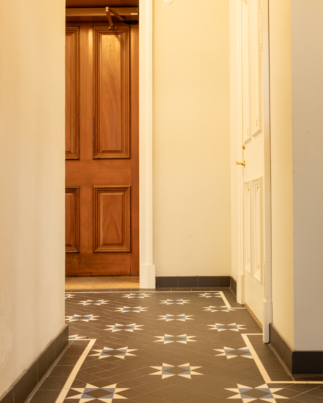 Victorian Floor Tiles i bl&aring;, hvid og sort med en bort, der indrammer klinkem&oslash;nstret