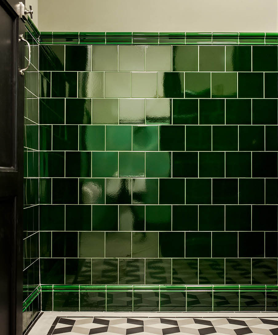 Restaurangtoalett med väggar klädda med kakel i kulören Victorian green. Profilplattorna Albert och Skirting inleder och avslutar.