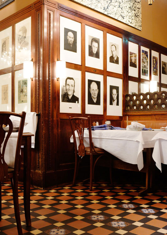 Restaurantafdeling med borde med hvide duge p&aring; et m&oslash;nstret klinkegulv af Victorian Floor Tiles