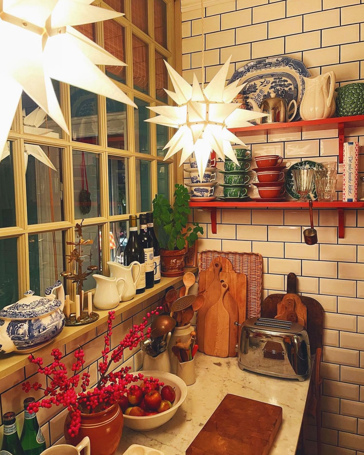 Herrnhuterstjerne i hvid som julebelysning i klassisk køkken med kakler, træskærebrætter og juledekoration. Herrnhuterstjerne i hvid som julebelysning i klassisk køkken med kakler, træskærebrætter og juledekoration.