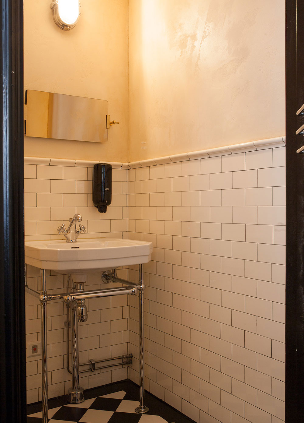 Toilet med halvtflisede v&aelig;gge i Half Tile-format og profileret afslutning